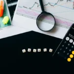 Analisis keuangan dengan grafik, kalkulator, dan data untuk menghitung BEP rupiah bisnis